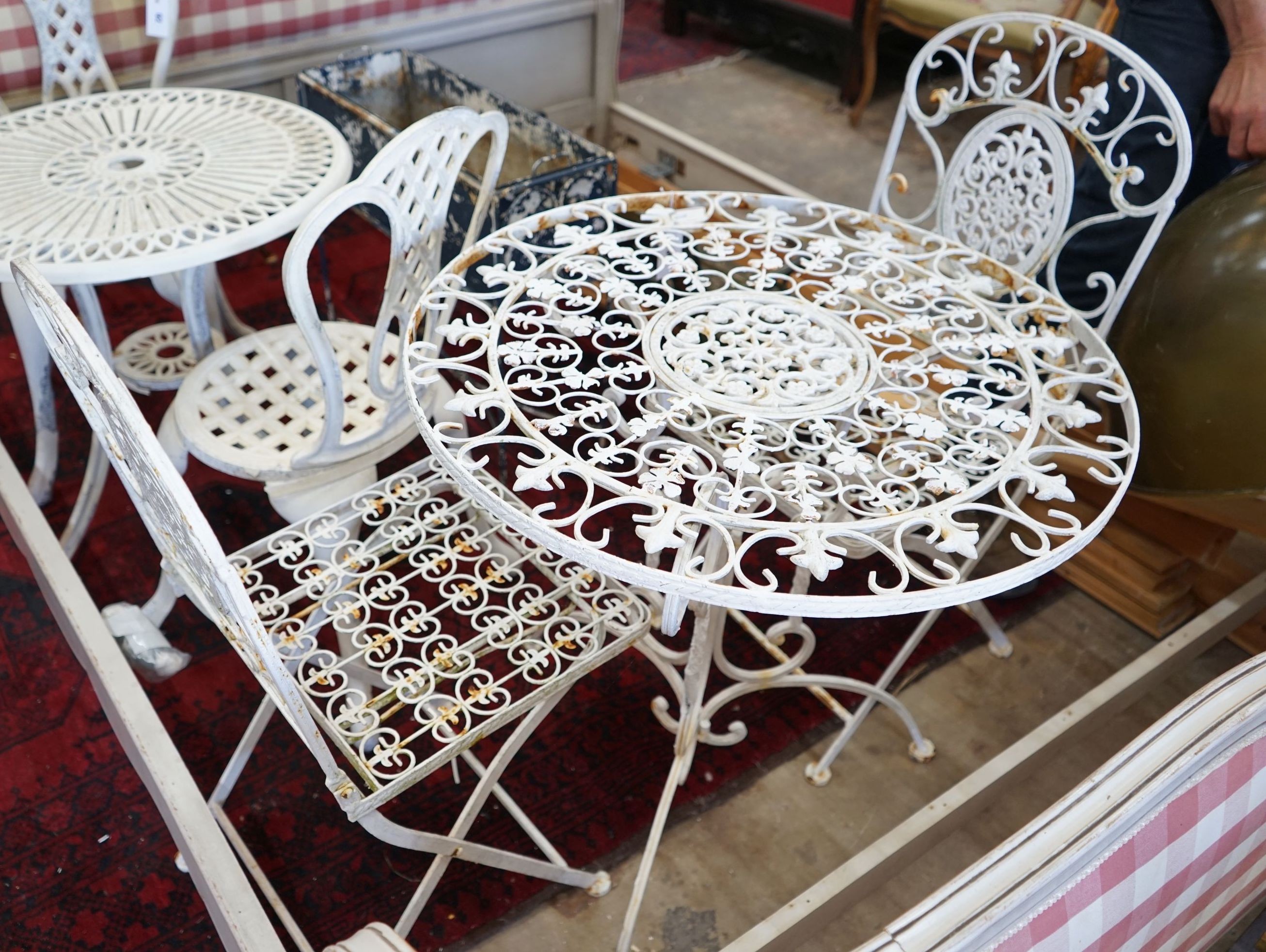 A painted circular metal garden table and 2 folding chairs, table 70 cms diameter.